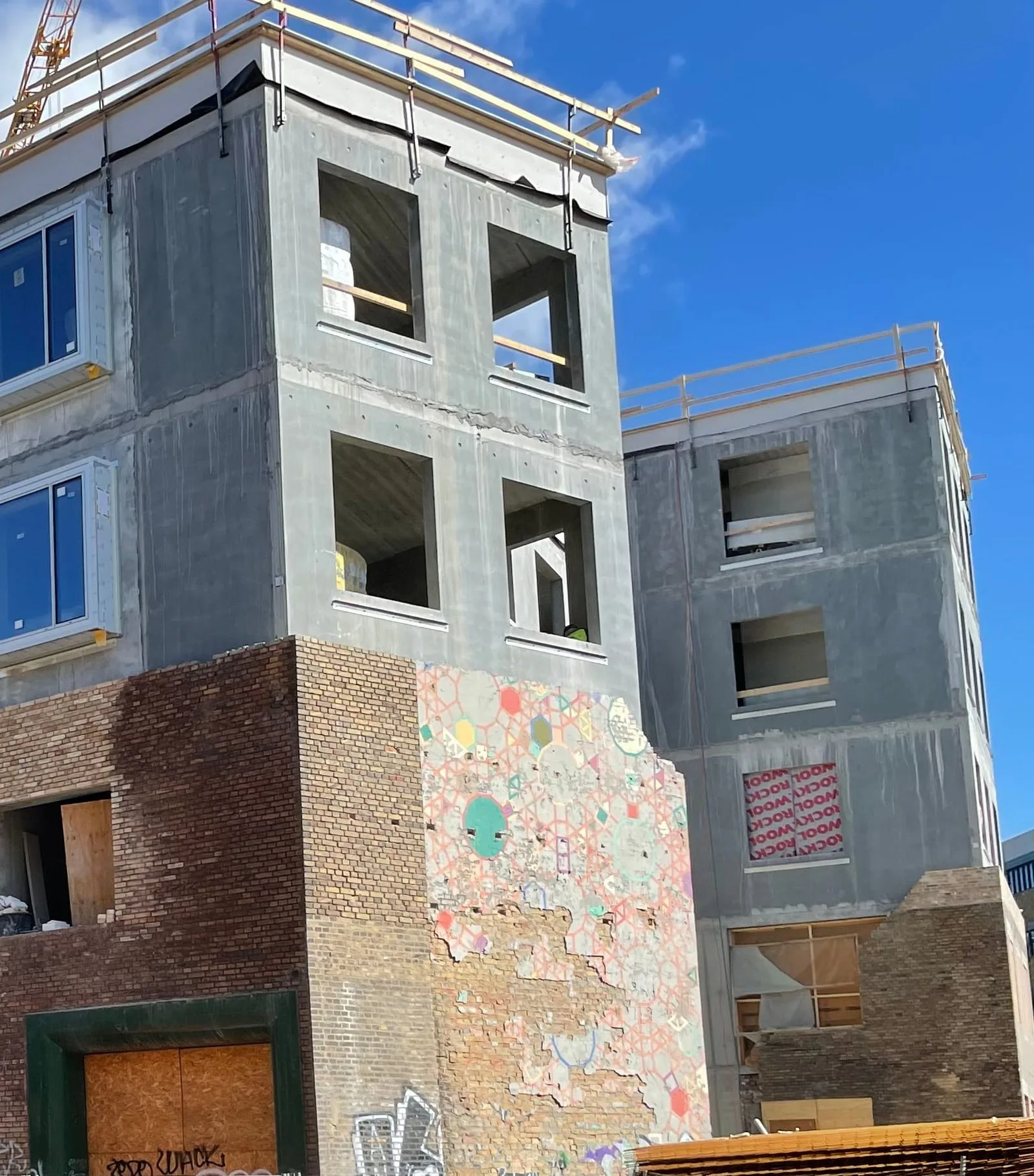 Hjørnet af ejendommen under opførelse med murstensfacade forneden og nye etager i beton ovenpå, Hermodsgade 26-28, København N