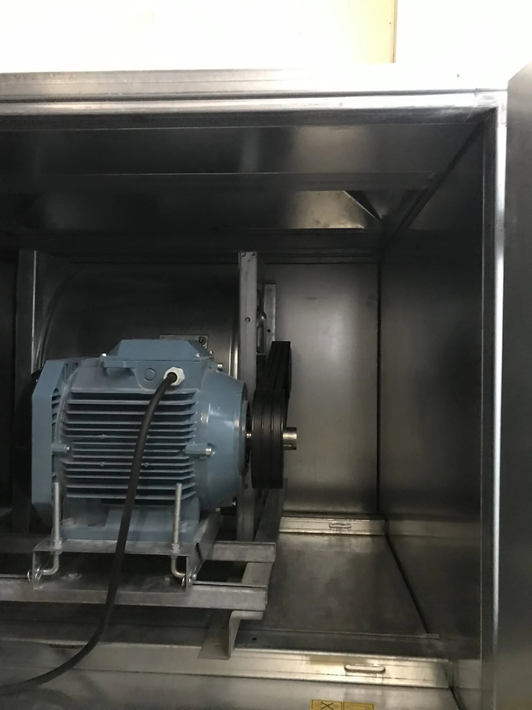 Ventilator med blå elmotor og remtræk i et åbent ventilatorkammer, Copenhagen Marriott Hotel, København