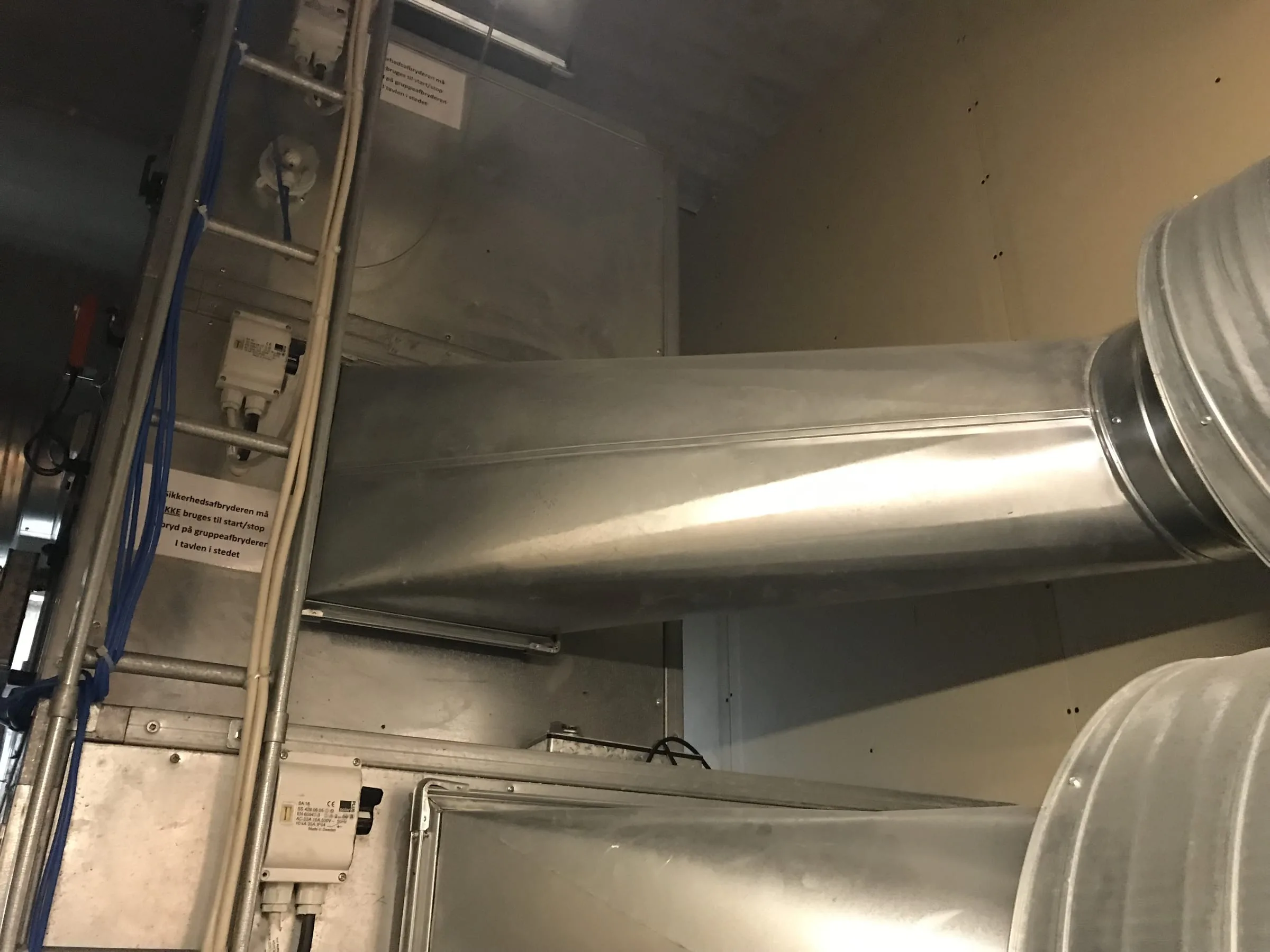Ventilatorkammer i stål med sikkerhedsafbrydere, kabelbakke og kanaler, der går over i runde spirokanaler, Copenhagen Marriott Hotel, København
